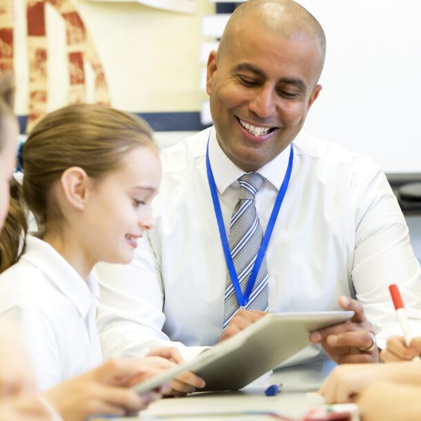 Male Teacher supporting students in class
